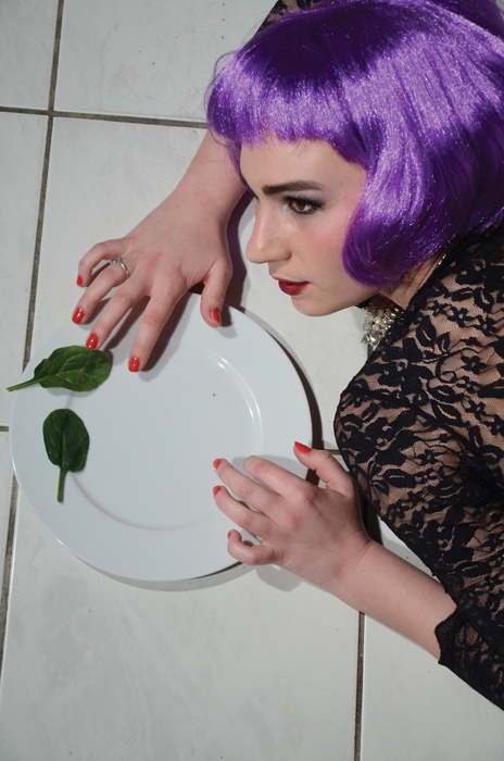 Femme avec une perruque et une assiette avec duex feuilles de salade - Projet photographique Food Porn